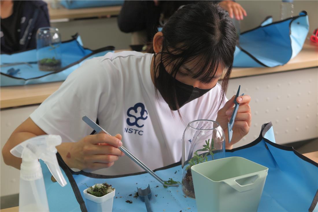 培訓隊選手雙手並用裝飾專屬於自己的植物生態瓶。